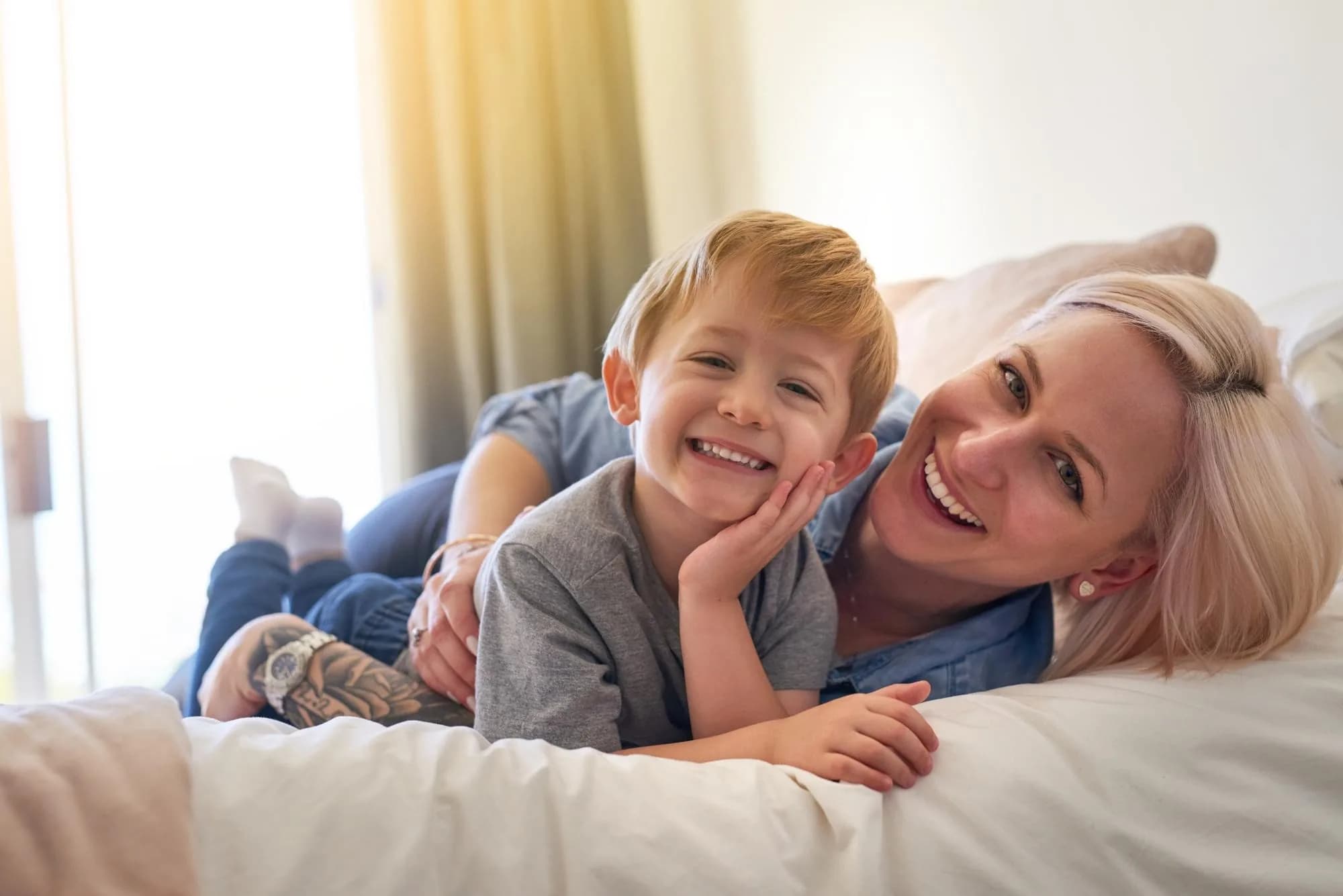 Smiling mother and young son enjoying family time — patients of Cy Becker Dental in Edmonton